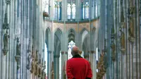 Staf pengawas (disebut Domschweizer) berdiri di dalam katedral Cologne, Jerman, Selasa (17/3/2020). Wabah virus corona COVID-19 yang merebak di Eropa saat ini berimbas pada tingkat kunjungan wisatawan ke Katedral Cologne yang kini sepi pengunjung. (Photo by Ina FASSBENDER / AFP)