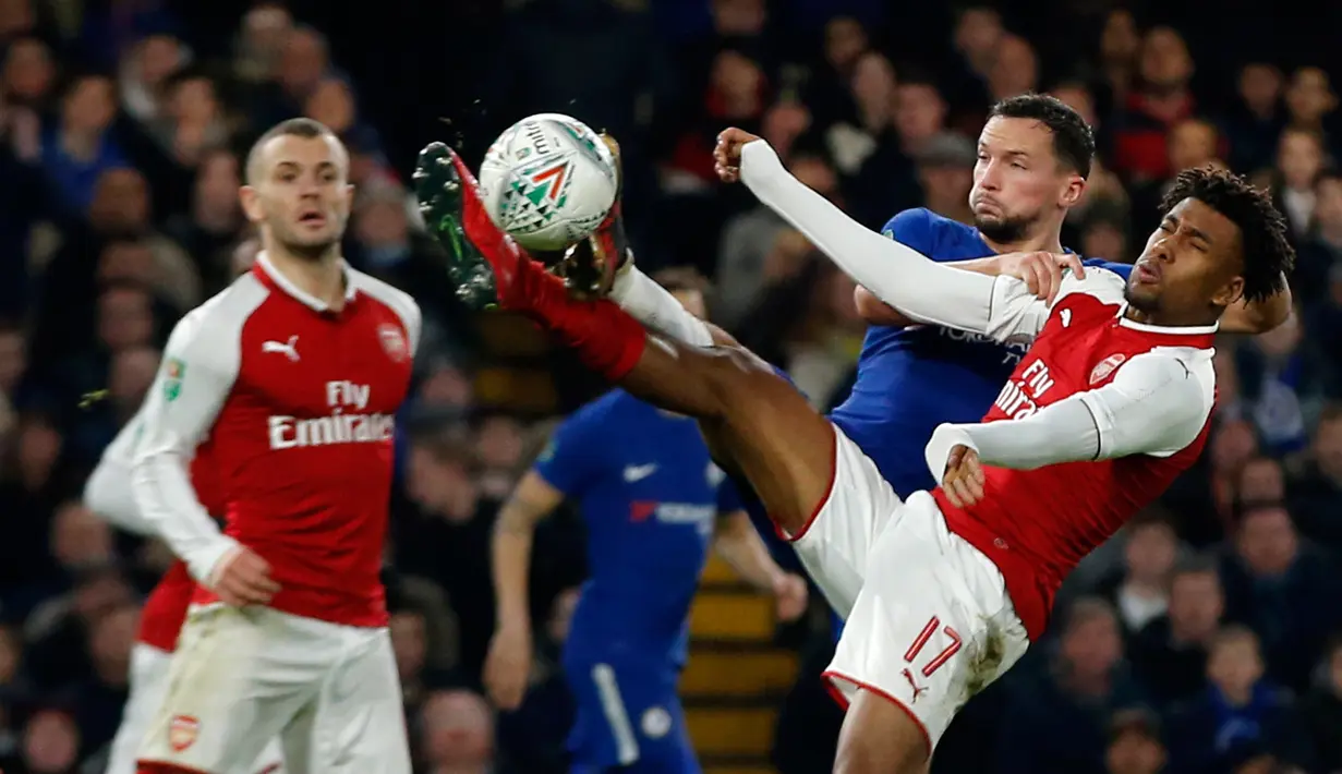 Pemain Arsenal, Alex Iwobi berebut bola dengan pemain Chelsea, Danny Drinkwater pada laga semifinal pertama Piala Liga Inggris di Stadion Stamford Bridge, Rabu (10/1). Chelsea dan Arsenal bermain imbang tanpa gol. (AP/Kirsty Wigglesworth)