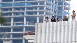 Pegawai berdiri dari lantai atas Gedung Balai Kota DKI menonton iringan massa aksi damai 4 November yang melewati kantor mereka, Jakarta, Jumat (4/11). Meski ada demo besar-besaran, pegawai Balai Kota tetap masuk seperti biasa (Liputan6.com/Faizal Fanani)