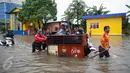 Penyedia jasa gerobak mengangkut warga dan motornya untuk menyeberangi banjir di Jalan Gunung Sahari, Jakarta Pusat, Selasa (21/2). Hujan deras yang mengguyur sejak Selasa dini hari membuat sebagian wilayah di Jakarta banjir. (Liputan6.com/Faizal Fanani)