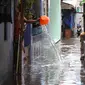 Seorang warga menguras air yang masuk kedalam rumahnya akibat banjir di kawasan Jatayu, Jakarta, Senin (21/11). Banjir disebabkan tingginya curah hujan dan buruknya saluran air serta meluapnya Kali Pesanggrahan. (Liputan6.com/Gempur M. Surya)