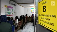 Wajib pajak dibantu petugas mengisi data di ruang Kelas Pajak EFILING di Kantor Pelayanan Pajak Pratama Jakarta, Kamis (29/3). Lonjakan wajib pajak terjadi jelang batas akhir penyampaian laporan SPT PPh orang pribadi. (Merdeka.com/Iqbal Nugroho)