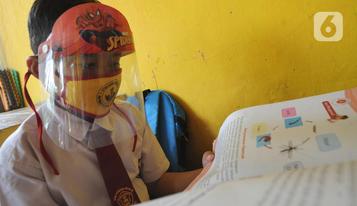 Murid kelas III SDN 02 Pondok Petir mengikuti kegiatan belajar mengajar di teras rumah salah satu siswa di Depok, Senin (31/08/2020). Mereka belajar 2 - 3 minggu sekali karena para siswa kesulitan belajar daring akibat beban paket data dan tidak semua memiliki smartphone. (merdeka.com/Arie Basuki)