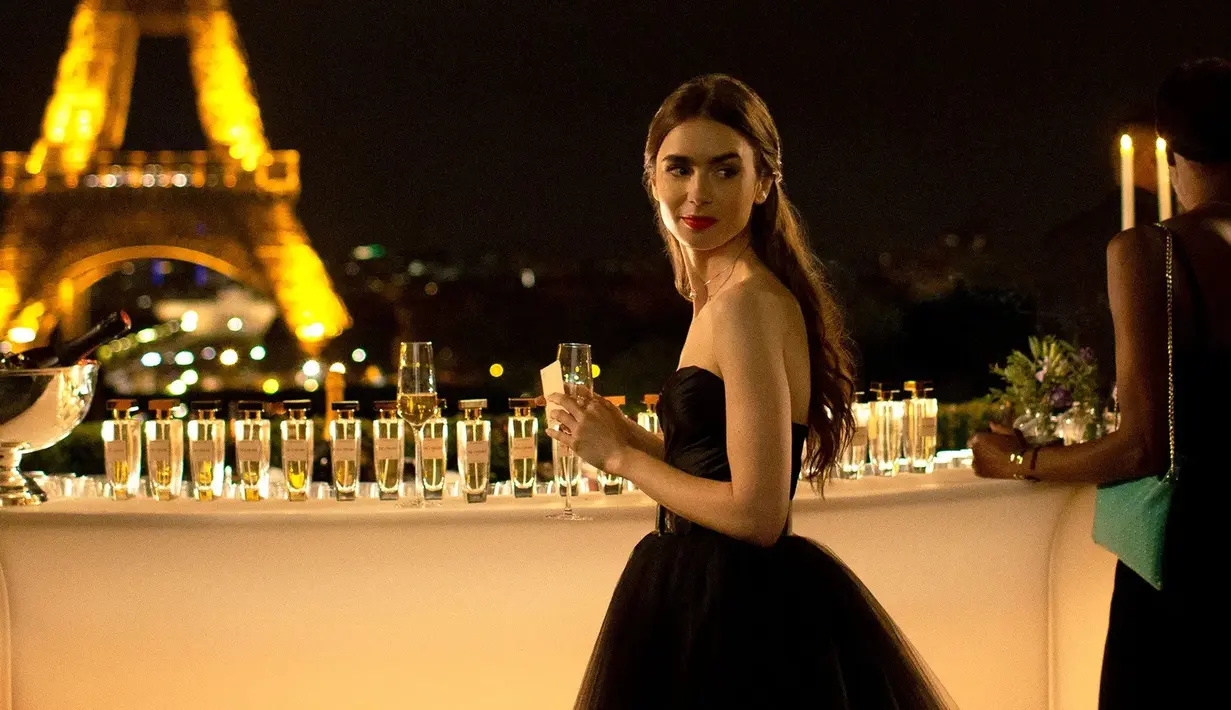 Ini adalah penampilan Lily Collins di Emily in Paris season 1. Ia mengenakan tulle skirt, strapless black top, dan Christian Louboutin sandals. Foto: Netflix.