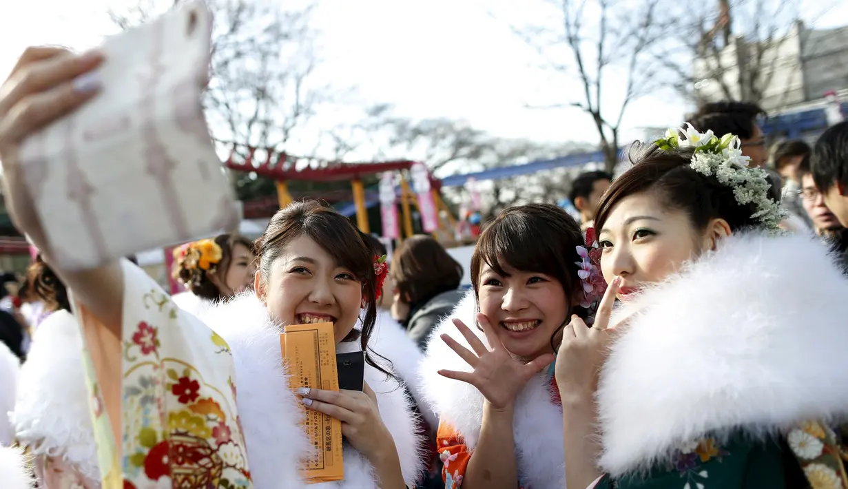 Wanita Jepang berpakaian kimono berselfie usai upacara Coming of Age Day (Hari Kedewasaan Nasional) di sebuah taman hiburan Tokyo, Senin (11/1). Hari Kedewasaan Nasional ini dirayakan para muda-mudi Jepang yang menginjak usia 20 tahun (REUTERS/Yuya Shino)
