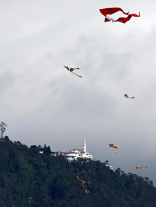 Orang-orang menerbangkan layang-layang selama festival musim panas di taman Simon Bolivar, Bogota, 12 Agustus 2018. Layang-layang beraneka warna dan bentuk menghiasi ibu kota Kolombia tersebut. (AFP PHOTO/John VIZCAINO)