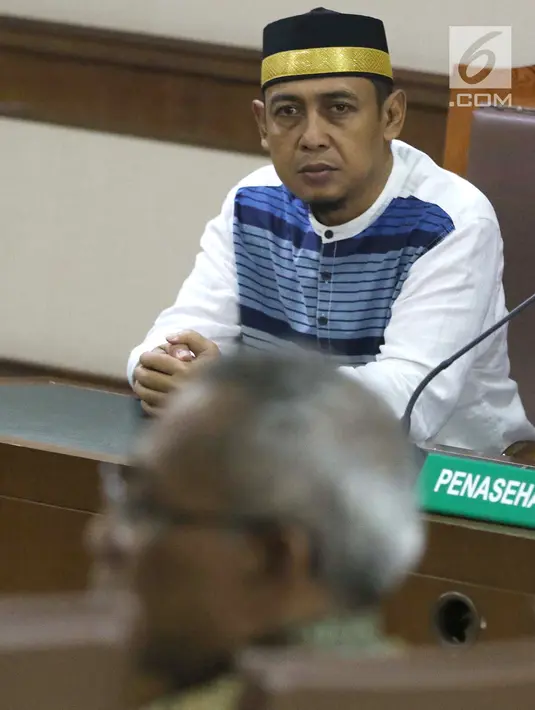 Terdakwa penyebaran berita bohong tentang 7 kontainer berisi surat suara Pemilu 2019 yang telah tercoblos, Bagus Bawana Putra menyimak keterangan Kepala Biro Hukum Sekjen KPU, Sigit Joyowardono saat sidang lanjutan di Pengadilan Negeri Jakarta Pusat, Kamis (11/4). (Liputan6.com/Helmi Fithriansyah)