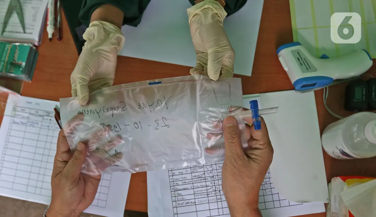 Petugas medis memberikan kantung udara kepada warga saat peluncuran Layanan GeNose C-19 di Kantor Dompet Dhuafa, Jakarta, Selasa (9/3/2021).  Dompet Dhuafa meluncurkan layanan pemeriksaan tes Covid-19 dengan menggunakan metode GeNose C-19. (Liputan6.com/Herman Zakharia)