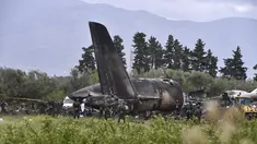 Petugas keamanan dan tim penyelamat berjaga di sekitar reruntuhan pesawat tentara Aljazair yang jatuh di dekat pangkalan udara Boufarik, Aljazair (11/4). Insiden ini menewaskan 257 orang yang berada di dalam pesawat tersebut. (AFP Photo/Ryad Krmadi)
