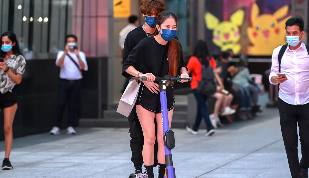 Sepasang muda-mudi mengenakan masker mengendarai skuter di sebuah jalan di Kuala Lumpur, Malaysia (24/11/2020). Malaysia pada Selasa (24/11) melaporkan 2.188 kasus baru COVID-19 dalam lonjakan harian tertinggi sejak wabah coronavirus merebak di negara itu. (Xinhua/Chong Voon Chung)