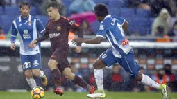 Aksi pemain FC Barcelona, Coutinho (tengah) melewati dua pemain Espanyol pada lanjutan La Liga santander di RCDE stadium, Cornella Llobregat, Spanyol, (4/2/2018). Espanyol dan Barcelona bermain imbang 1-1. (AP/Manu Fernandez)