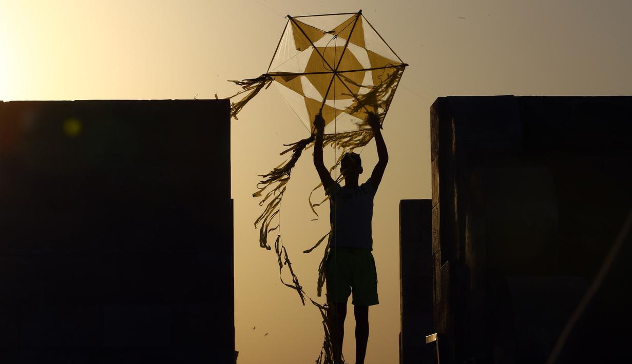 Seorang pria bersiap menerbangkan layang-layang di atap sebuah gedung selama masa pandemi COVID-19 di Kairo, Mesir pada Senin (11/5/2020). Mesir mencatatkan peningkatan harian sebanyak 346 kasus infeksi COVID-19, menambah jumlah kasus terkonfirmasi di negara itu menjadi 9.746. (Xinhua/Ahmed Gomaa)