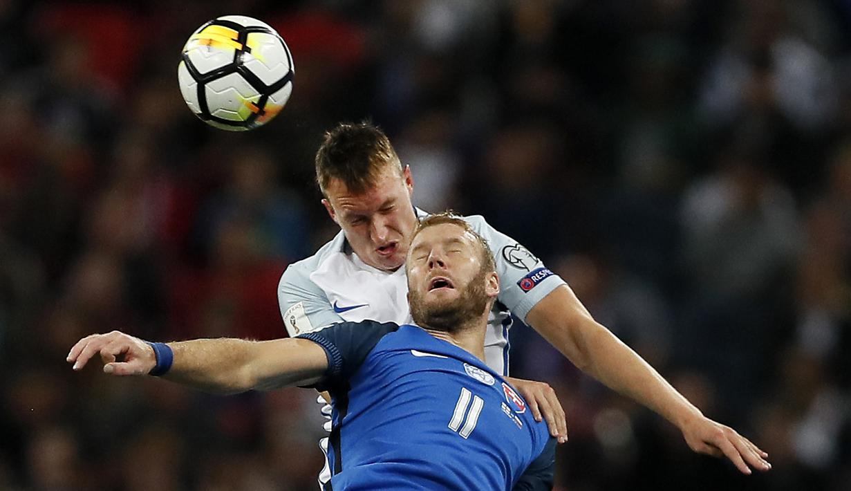 Duel pemain Inggris, Phil Jones (atas) dan pemain Slovakia, Adam Nemec pada laga grup F kualifikasi Piala Dunia 2018 di Wembley stadium, London, (4/9/2017). Inggris menang 2-1. (AP/Kirsty Wigglesworth)
