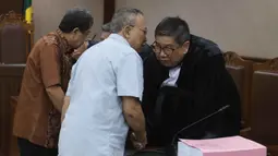 Tiga terdakwa tersebut adalah Direktur Utama PT Pertamina Patra Niaga (PPN) periode 2021-2023 Alfian Nasution, Direktur Pemasaran dan Niaga Pertamina periode 2012-2014 Hanung Budya Yuktyanta, serta Business Development Manager Trafigura Pte Ltd periode 2019-2021 Martin Haendra Nata. Tampak dalam foto, terdakwa kasus dugaan korupsi tata kelola minyak mentah, Hanung Budya Yuktyanta (tengah) berbincang penasehat hukumnya usai mengikuti sidang pembacaan tuntutan di Pengadilan Tindak Pidana Korusi (Tipikor), Jakarta, Kamis (23/4/2026). (Kapanlagi.com/Budy Santoso)