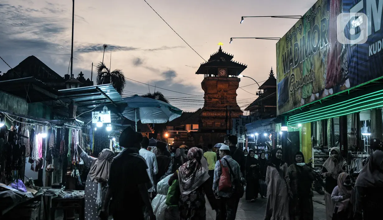 Pengunjung berjalan di dekat Menara Kudus, Kauman, Kabupaten Kudus, Jawa Tengah, Rabu (30/3/2022). Menara berusia 473 tahun yang dahulu berfungsi sebagai tempat mengumandangkan azan menjadi lokasi favorit pengunjung untuk bersantai usai berziarah di Makam Sunan Kudus. (merdeka.com/Iqbal S. Nugroho)