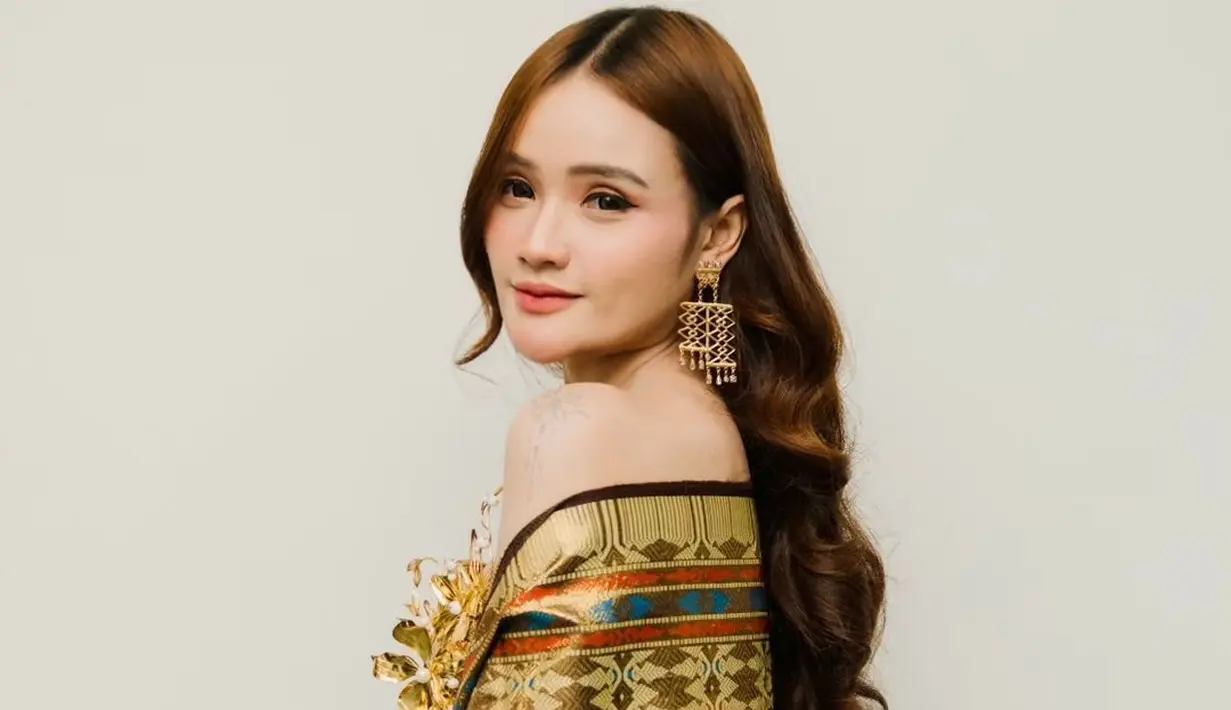 Fanny Soegiarto terlihat menawan dalam busana ageman bernuansa emas. Ia padukan strapless dress dengan wastra sebagai selendang [@fannysoegi]