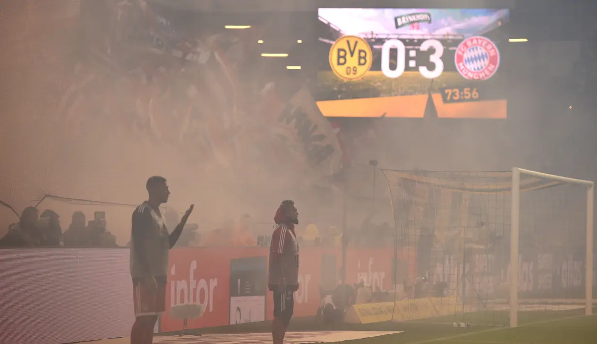 Asap tebal dari flare menyelimuti lapangan saat laga Borussia Dortmund melawan Bayern Munchen pada lanjutan Bundesliga di Signal Iduna Park, Dortmund, (4/11/2017). Bayern menang 3-1. (AFP/Patrik Stollarz)