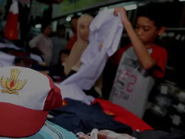 Calon pembeli melihat baju seragam yang dijual di Pasar Senen, Jakarta, Selasa (12/7). Penjualan seragam sekolah menjelang tahun ajaran baru mengalami peningkatan sekitar 30-50 persen dari hari biasa. (Liputan6.com/Gempur m Surya)