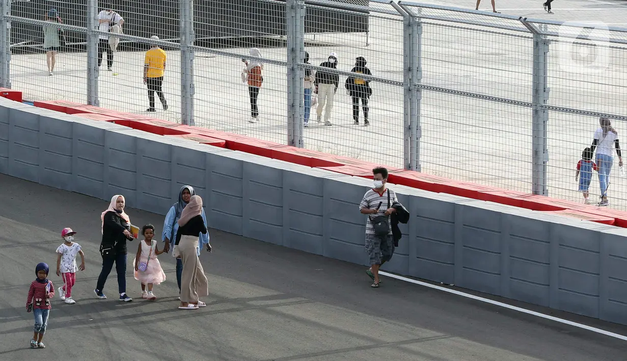 Warga berjalan saat parade dalam pagelaran Jakarnaval 2022 di Jakarta International Eprix Circuit, Ancol, Minggu (14/8/2022). Gelaran Jakarnaval 2022 yang mengangkat tema "Kekayaan Intelektual Nusantara untuk Dunia" tersebut menampilkan parade komunitas pegiat seni budaya, marching band, dan kendaraan hias. (Liputan6.com/Herman Zakharia)