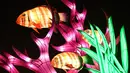 Gambar pada 15 November 2019 menunjukkan patung ikan diterangi lampu berwarna sebagai bagian dari pameran festival cahaya di Kebun Binatang Jardin des Plantes, Paris. Festival Cahaya bertajuk "Ocean en voie d'illumination" ini digelar dari 18 November 2019 - 19 Januari 2020. (BERTRAND GUAY/AFP)