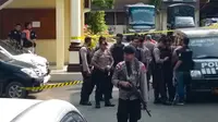Polisi berjaga setelah pelaku bom bunuh diri meledakkan dirinya di Mapolrestabes Medan, Sumatera Utara, Rabu (13/11/2019). Area Mapolrestabes Medan dijaga ketat aparat kepolisian bersenjata lengkap. (Rahmad SURYADI/AFP)