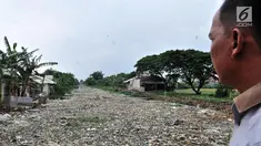 Warga melihat tumpukan sampah yang memenuhi Kali Pisang Batu di Tarumajaya, Kabupaten Bekasi, Jawa Barat, Rabu (9/1). Tumpukan sampah tersebut berasal dari limbah rumah tangga. (Merdeka.com/Iqbal S Nugroho)