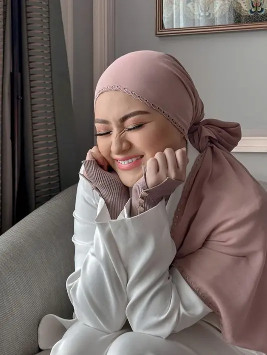 Ibu satu anak ini juga tampil menggemaskan dengan kerudung model ikat ke belakangnya, dengan mengenakan makeup blush on, eyeshadow coklat dan eyeliner wings nya. Ia pun memoles bibirnya dengan lipstik pinknya. @nathalieholscher