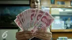 Petugas menunjukkan uang pecahan 100 Yuan di tempat penukaran uang, Jakarta, Kamis (13/8/2015). Kebijakan Tiongkok yang sengaja melemahkan (devaluasi) mata uang Yuan membuat Rupiah melemah terhadap dolar AS. (Liputan6.com/Johan Tallo)