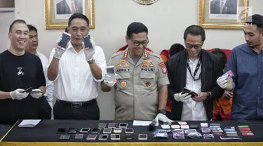 Kabid Humas Polda Metro Jaya Kombes Pol Argo Yuwono menunjukkan barang bukti kasus order fiktif pada transportasi online di Polda Metro Jaya, Jakarta, Rabu (13/2). Kasus ini diungkap oleh Satgas Cyber Crime Polda Metro Jaya. (Liputan6.com/Faizal Fanani)