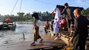 Ketetapan tersebut tertuang dalam Surat Edaran bernomor 400.3/2026 yang ditandatangani Kepala Dinas Pendidikan dan Kebudayaan Kabupaten Bireuen, dan ditujukan kepada seluruh Kepala UPTD PAUD, SD, dan SMP. Tampak dalam foto, sejumlah siswa menaiki perahu darurat untuk menyeberangi Sungai Peusangan pasca banjir bandang yang menghancurkan desa-desa di sekitarnya di kabupaten Bireuen, provinsi Aceh, Indonesia pada Senin 5 Januari 2026. (CHAIDEER MAHYUDDIN/AFP)
