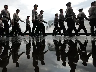 Personel kepolisian berjalan usai melakukan pengamanan gedung DPR RI, Jakarta, Kamis (30/3). Pengamanan terkait isu aksi massa pada 30 dan 31 Maret 2017. (Liputan6.com/Helmi Fithriansyah)
