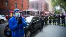 Warga berkumpul di luar rumah sakit mengungkapkan rasa terima kasih dan hormat kepada petugas kesehatan di New York, (16/4/2020). Setiap malam pukul 19.00 waktu setempat, warga bertepuk tangan menyemangati pekerja esensial mendukung dan mengapresiasi selama pandemi COVID-19. (Xinhua/Michael Nagle)