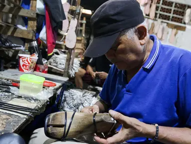 Pekerja sedang menyelesaikan pembuatan sepatu sandal wanita di salah satu industri rumahan yang ada di kawasan Bogor, Jawa Barat, Selasa (25/2/2025). (Liputan6.com/Herman Zakharia)