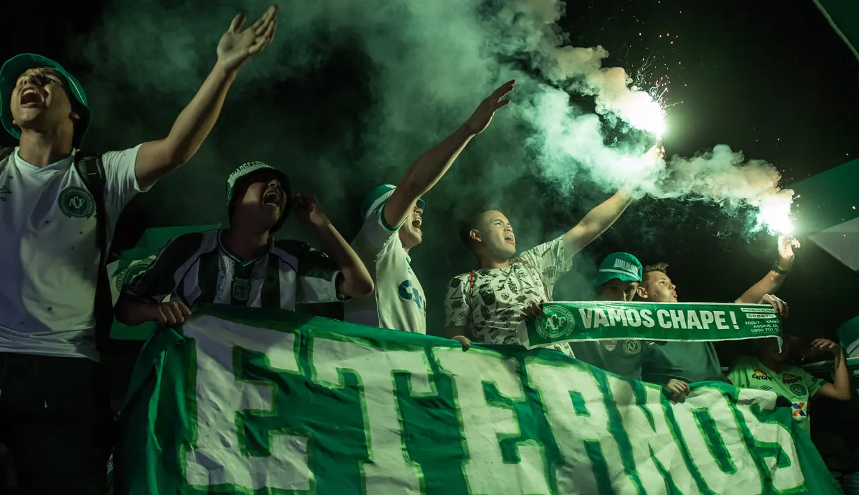 Fans menyalakan flare saat memperingati satu tahun kecelakaan pesawat Lamia 2933 yang menewaskan penumpang dan pemain klub Chapecoense di Arena Conda stadium, Chapeco, Santa Catarina, Brasil, (28/11/2017). sekitar 19 pemain meninggal. (AFP/Nelson Meida)