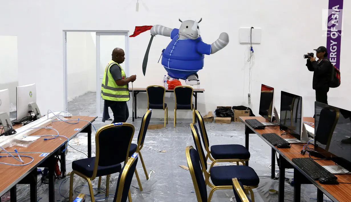 Pekerja melintas di Main Press Center (MPC) atau media center bagi jurnalis untuk pelaksanaan Asian Games 2018 terus dibangun di Exhibition Hall JCC, Jakarta, Kamis (9/8). MPC akan beroperasi pada 10 Agustus. (Liputan6.com/Fery Pradolo)