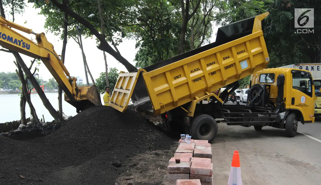 Truk menurunkan pasir saat penataan Danau Sunter, Jakarta Utara, (19/2). Menurut rencana, Festival Danau Sunter akan dimeriahkan sejumlah atraksi dari berbagai komunitas olahraga air seperti ski, renang, dan dayung. (Liputan6.com/Arya Manggala)