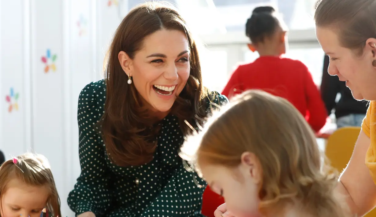 Kate Middleton tertawa saat bermain dengan pasien anak di Rumah Sakit Anak Evelina di London, Inggris (11/12).Kate dan suaminya pangeran William mengajak para pasien anak untuk merayakan Natal. (Chris Jackson/Pool via AP)