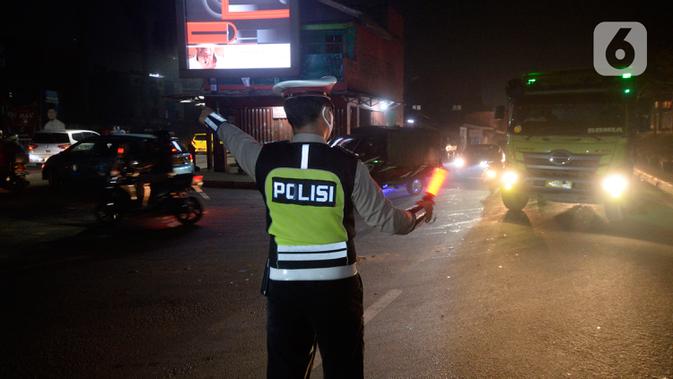 Petugas kepolisian saat pengalihan arus lalu lintas di depan RS Sari Asih, Tangerang Selatan, Sabtu (9/5/2020). Pengalihan arus dalam rangka pelaksanaan Pembatasan Sosial Berskala Besar (PSBB)  untuk memutus penularan Covid-19 di wilayah Tangsel mulai jam 22.00 - 05.00. (merdeka.com/Dwi Narwoko)