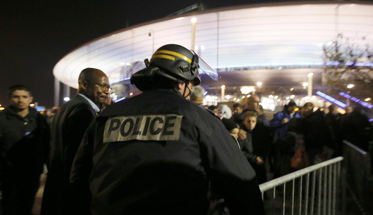Polisi mengatur para penonton yang akan meninggalkan stadion usai laga antara Prancis melawan Jerman di Stadion Stade de France, Prancis, Sabtu (13/11/2015). (Reuters/Gonzalo Fuentes)