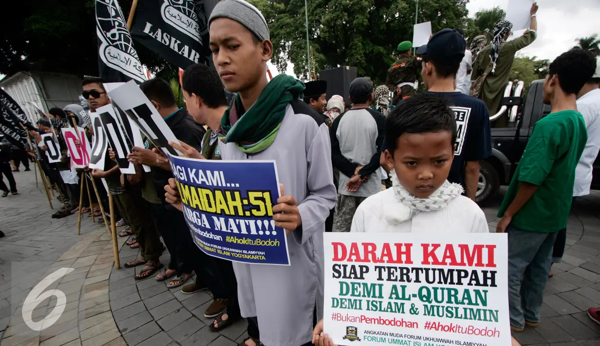 Sejumlah massa dari ormas Islam se- DIY membawa poster saat tabligh akbar di Titik Nol km, Yogya, Minggu (9/10). Mereka mendukung PP Muhammadiah yang telah melaporkan Ahok ke Polda Metro Jaya atas penistaan agama. (Liputan6.com/ Boy Harjanto)