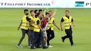 Petugas keamanan berhasil mengamankan seorang suporter yang masuk kedalam lapangan setelah laga FIFA Matchday antara Timnas Indonesia Vs Timnas Argentina di Stadion Utama Gelora Bung Karno (SUGBK), Senayan, Jakarta, Senin (19/06/2023). (Bola.com/M Iqbal Ichsan)