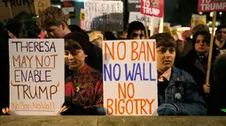 Demonstran membentangkan poster saat unjuk rasa di luar Downing Street, London, Senin (30/1). Mereka memprotes kebijakan Presiden AS Donald Trump yang melarang Muslim dari sejumlah negara memasuki Amerika Serikat. (AP Photo/Alastair Grant)