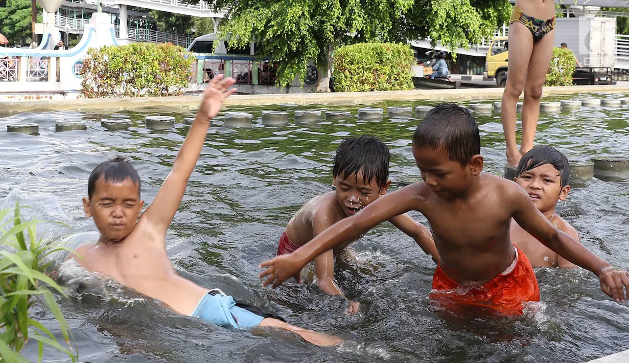 Anak-anak bermain di kolam air mancur penghias kawasan Pasar Baru, Jakarta, Selasa (29/1). Keterbatasan lahan bermain menyebabkan sebagian anak di Ibukota bermain tidak pada tempatnya, meskipun berbahaya bagi keselematan. (Liputan6.com/Immanuel Antonius)