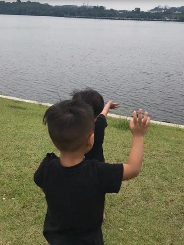 Terpisah karena Lockdown, Bapak dan Anak Saling Melambaikan Tangan dari Seberang Sungai