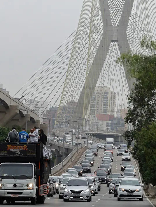 Ratusan pengemudi Uber saat unjuk rasa di Sao Paulo, Brasil (30/10). Mereka memprotes adanya aturan baru yang dibuat pemerintahannya dan dapat mengubah status mereka sama seperti taksi konvensional. (AP Photo / Andre Penner)