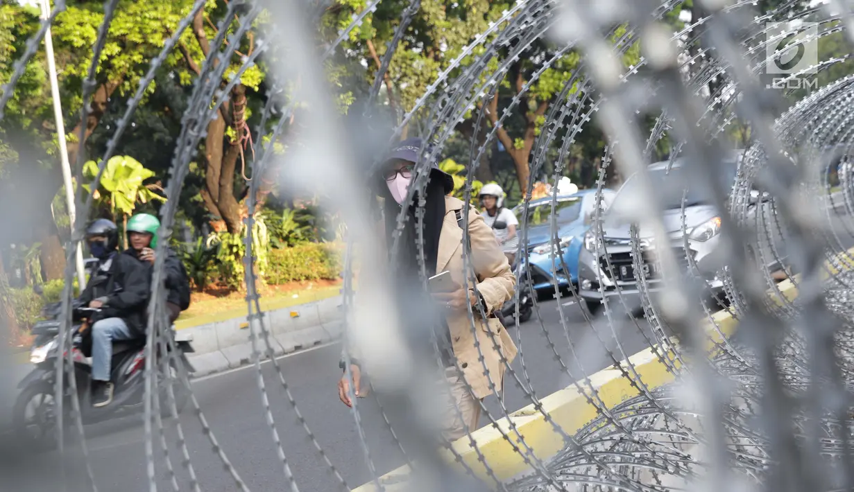 Pejalan kaki melintas di depan Gedung Mahkamah Konstitusi (MK), Jakarta, Selasa (25/6/2019). Jelang sidang pembacaan putusan akan digelar pada Kamis (27/6), sekitar 47.000 personel keamanan gabungan akan disiagakan di Ibu Kota DKI Jakarta. (Liputan6.com/Helmi Fithriansyah)
