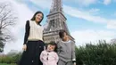 Tak lengkap rasanya jika ke Paris tanpa berfoto di menara  Eiffel. Sarwendah dengan atas vest kotak-kotak dan inner hitam, dipadukan rok tulle berkilau pun foto di bawah menara Eiffel bersama kedua anaknya. @sarwendah29