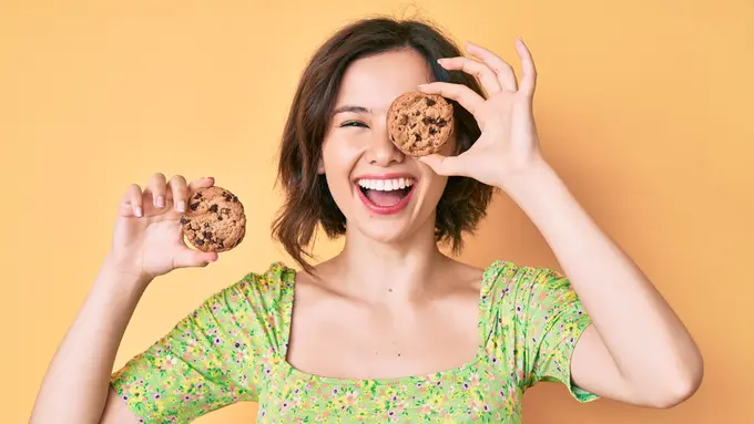 perempuan memegang kue kering