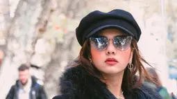 Tampil dengan makeup tebal dan memakai kacamata serta topi, membuat pemeran Gina di sinetron Dari Jendela SMP ini terlihat begitu modis. Terlebih, gayanya ini modis dengan padu padan warna dari topi hingga busana ialah warna hitam. (Liputan6.com/IG/@sabrindh)