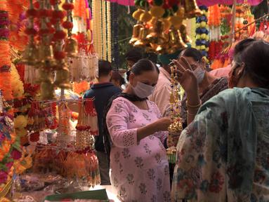 Orang-orang membeli barang-barang dekorasi menjelang festival Diwali di sebuah pasar di Amritsar, India pada 10 November 2020. Tahun ini festival lampu Diwali jatuh pada 14 November mendatang. (Photo by NARINDER NANU / AFP)